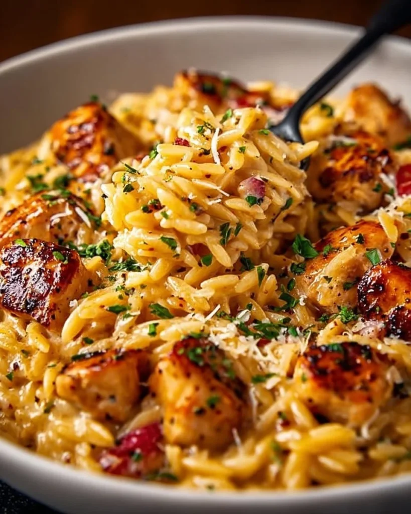 One-pot Cajun Chicken Alfredo Orzo served in a bowl with fresh herbs