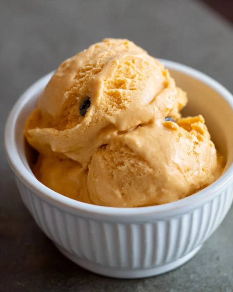 Homemade doggy ice cream in a bowl with a happy dog enjoying it.