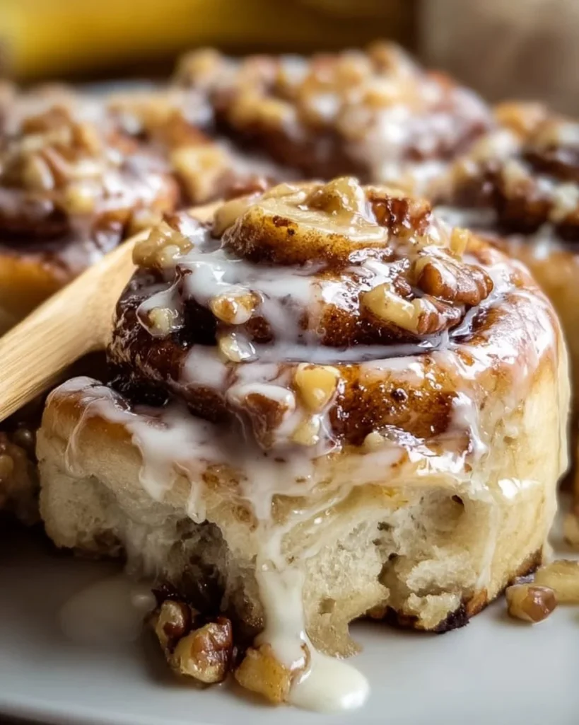 Freshly baked Banana Nut Cinnamon Rolls with nuts and cinnamon on a plate