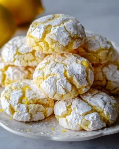 Delicious Lemon Crinkle Cookies dusted with powdered sugar on a baking tray