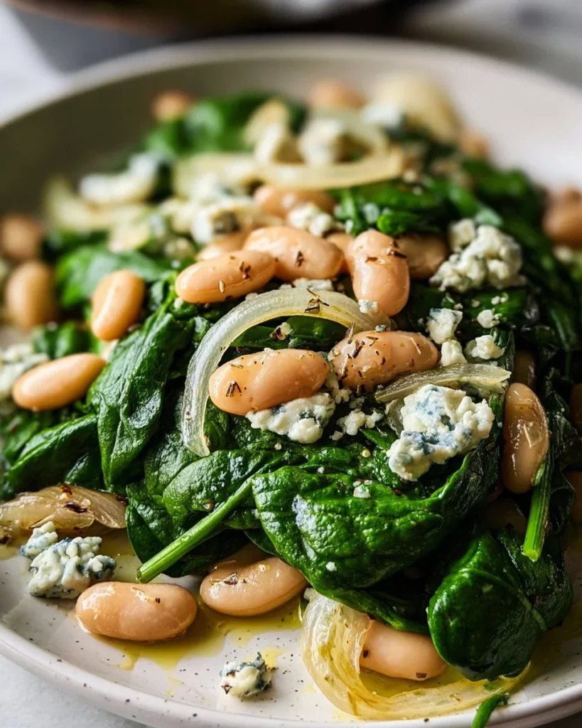Sautéed spinach and white bean salad in a bowl, garnished and ready to serve.