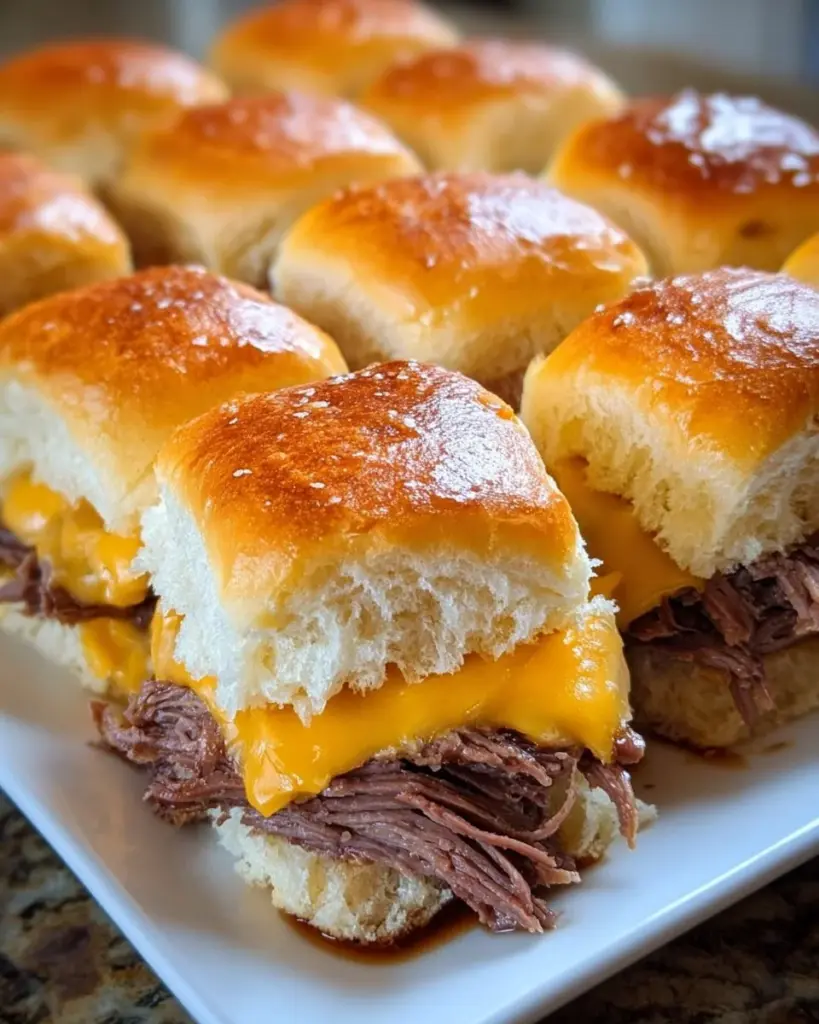 Crock pot beef cheddar sliders ready to serve with melted cheese and tender beef