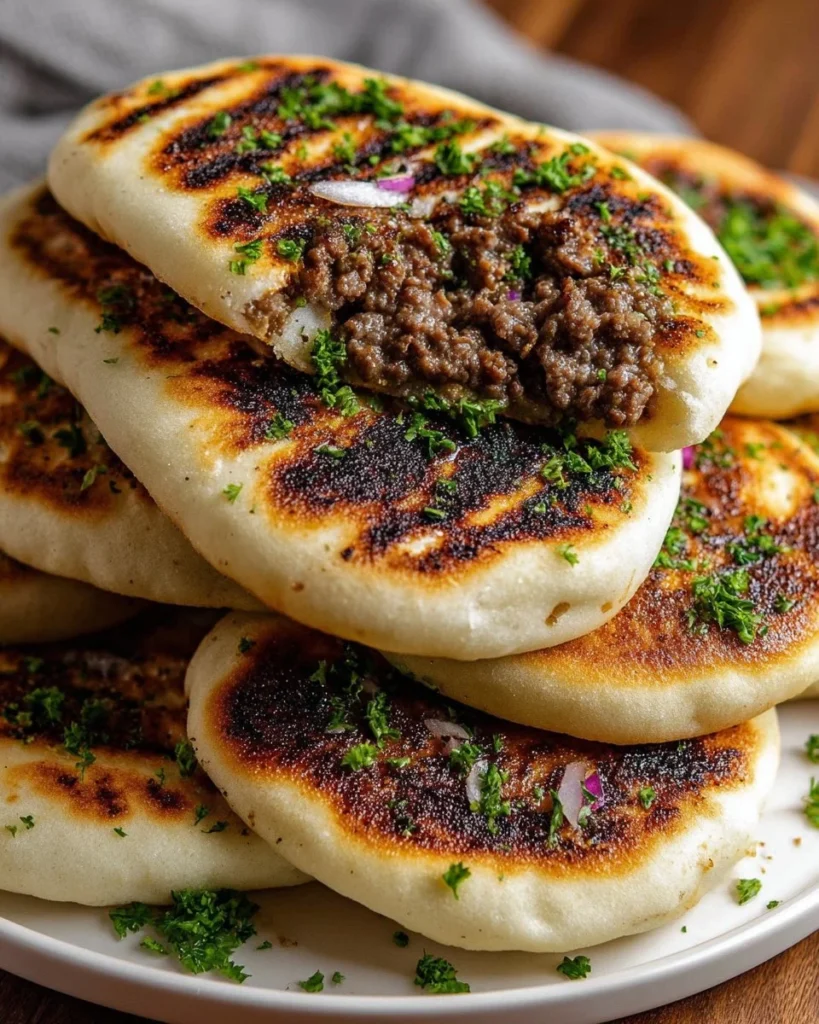 Grilled lamb pita arayes served on a plate with fresh herbs and spices