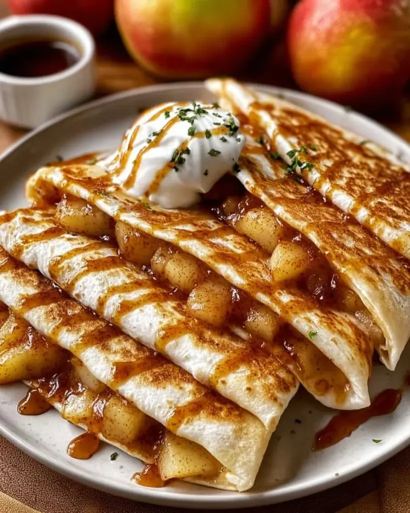 A serving of apple cinnamon breakfast quesadillas with a side of maple syrup.