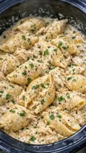 A plate of creamy garlic parmesan chicken shells served with a fresh garnish.